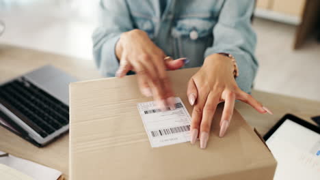 woman attaching a shipping label to a package