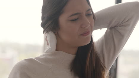 Mujer-Que-Sufre-Tratando-De-Aliviar-El-Dolor-De-Cuello-Con-Una-Bolsa-De-Hielo-Mientras-Se-Sienta-En-El-Sofá-En-Casa