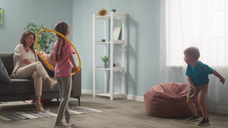 woman throws toy to little son daughter jumps through hoop