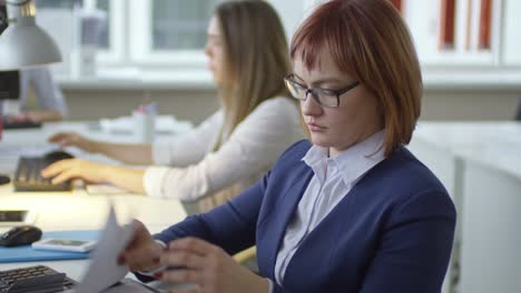 business lady talking and giving document to colleague in office