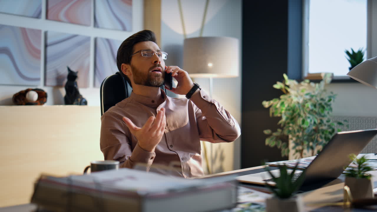 Businessman calling office desk looking work papers. Manager talking smartphone.