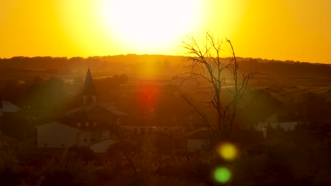 Beautiful-rural-residential-landscape-with-golden-sun-flare-over-mountain-silhouette