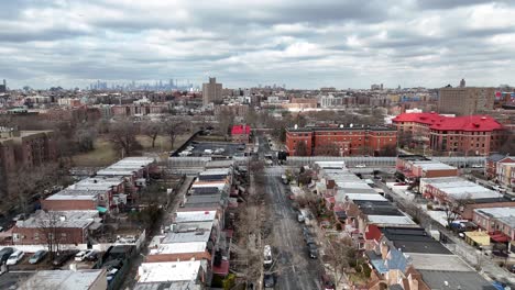 horizontal drone ascending shot over troy ave, brooklyn, revealing new york’s vibrant rooftops, urban streets, and dynamic cityscape from a rising aerial perspective.
