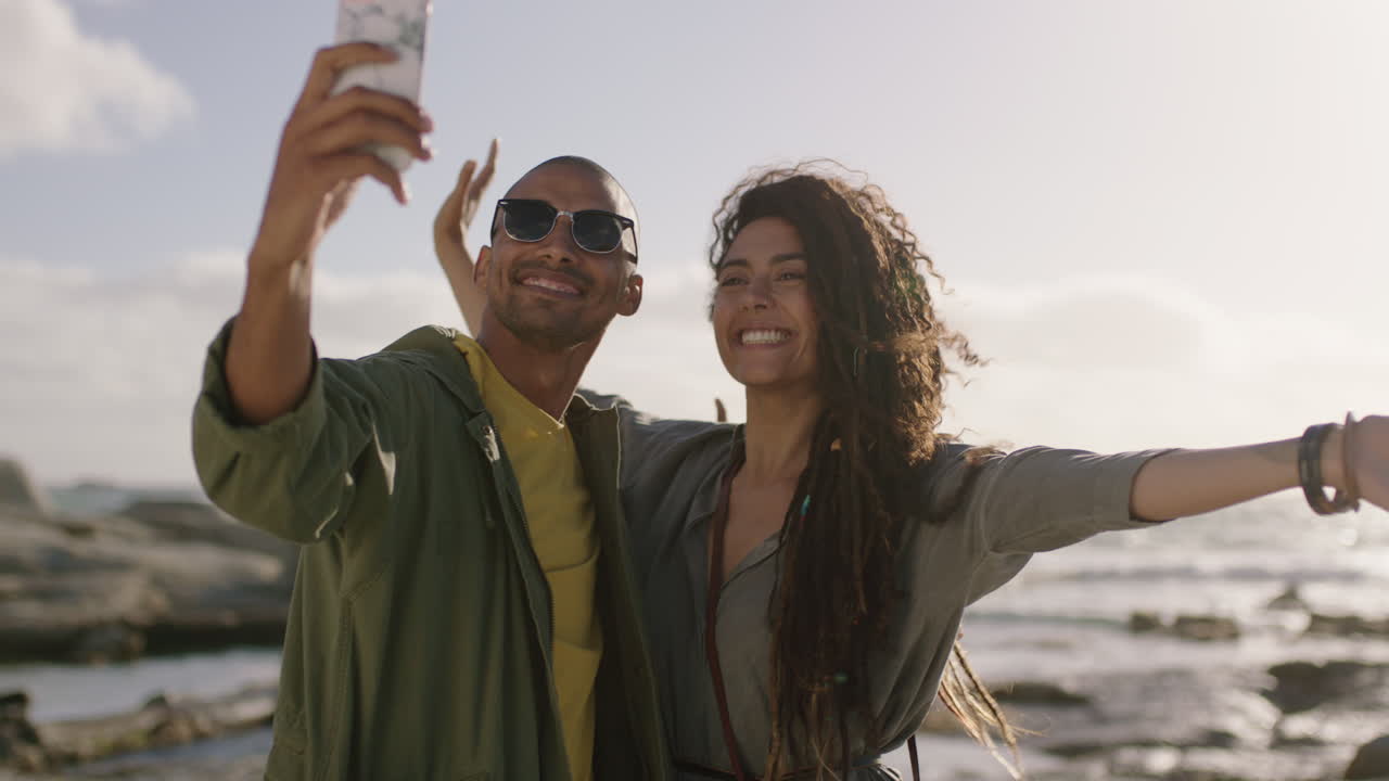 alegre feliz pareja de raza mixta posando para una selfie en la playa