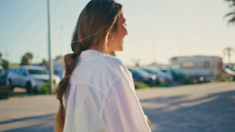 cheerful woman turning camera walking alley portrait. girl crossing palm street