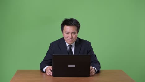 녹색 배경에 성숙한 일본 사업가