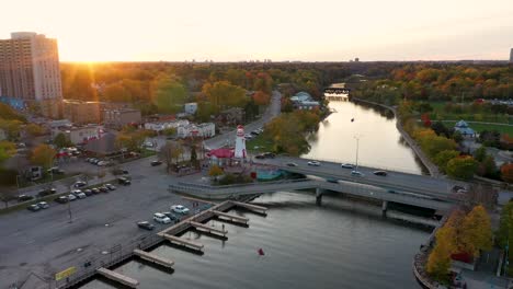 drone flying towards a lighthouse at sunrise at mississauga harbor