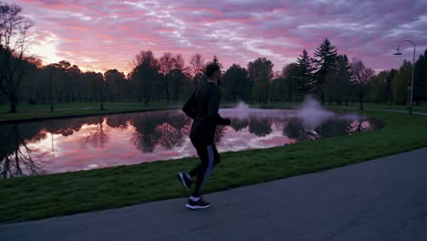 athlete running along lakeside park path during dawn, embracing early morning serenity and peaceful landscape while engaging in fitness routine