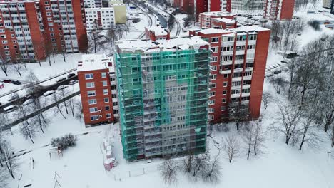 renovating a building in winter, snowy cityscape from drone