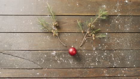 Video-of-christmas-red-bauble-decoration-with-copy-space-on-wooden-background