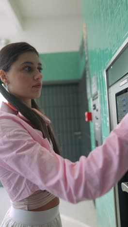 woman using a coin-operated laundry machine