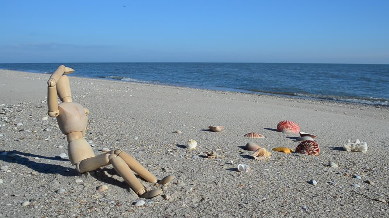 Manichino di legno sulla spiaggia. Riprese sulla spiaggia