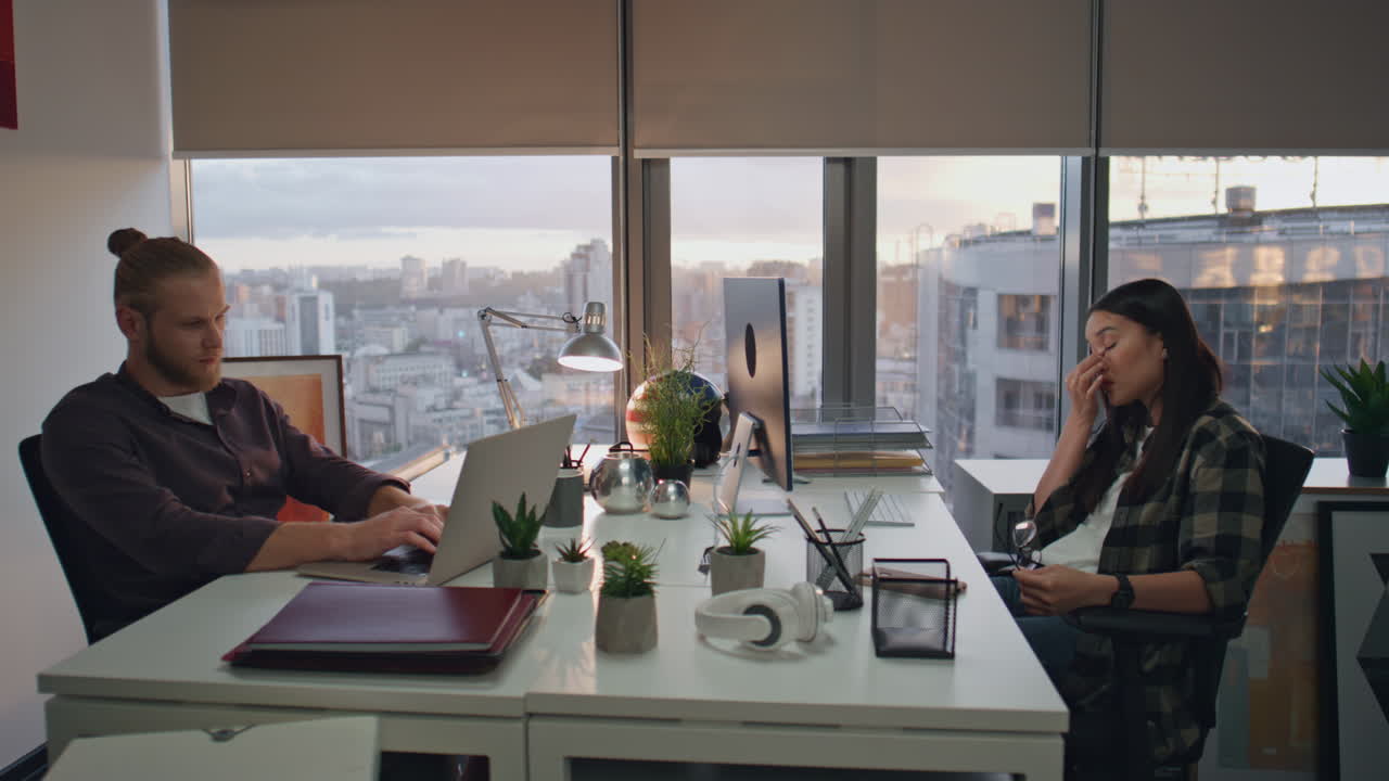 emprendedores cansados trabajando hasta tarde en la oficina cerca de los compañeros de trabajo tratando de alcanzar la fecha límite