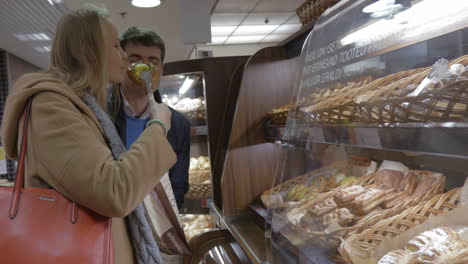 man and woman buying delicious bun in the shop