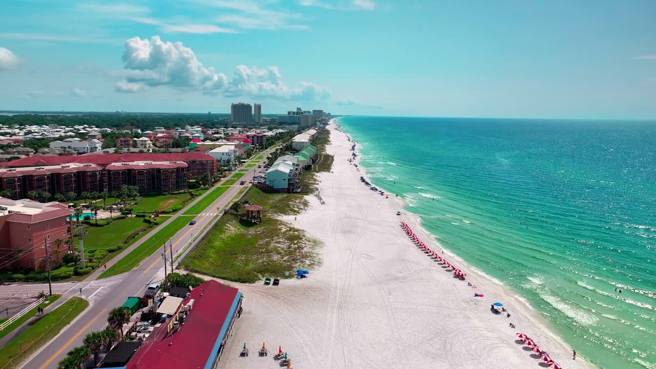 volando sobre el restaurante pompano joe en destin florida con una vista de la vieja 98 hwy y la playa de arena blanca en el golfo de méxico