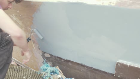 primero gris rodante en el casco de un barco de madera