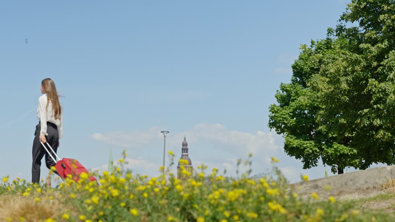 женщина-предприниматель проходит через экран, тянув красный чемодан.