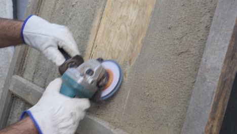 close-up of a radial power saw being used with protective gloves to restore and polish an old piece of wood