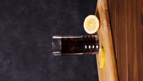 piscola cóctel, bebida típica chilena mesa de madera fondo oscuro chile pisco, hielo y coca