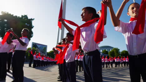 children in red scarves at a ceremony