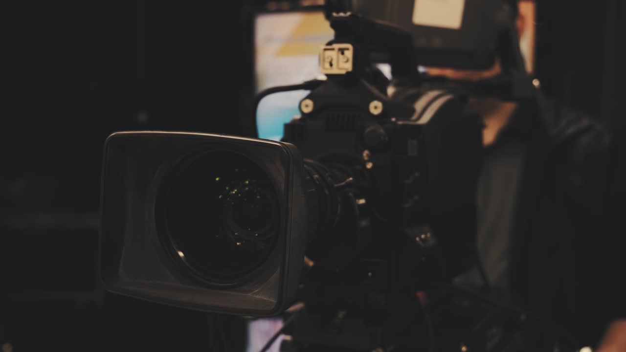 Professional cameraman with headphones with HD camcorder in live television. Television industry