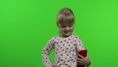 Kid-girl-using-smartphone.-Child-emotionally-makes-selfie-on-mobile-phone.-Video-call,-blog,-game