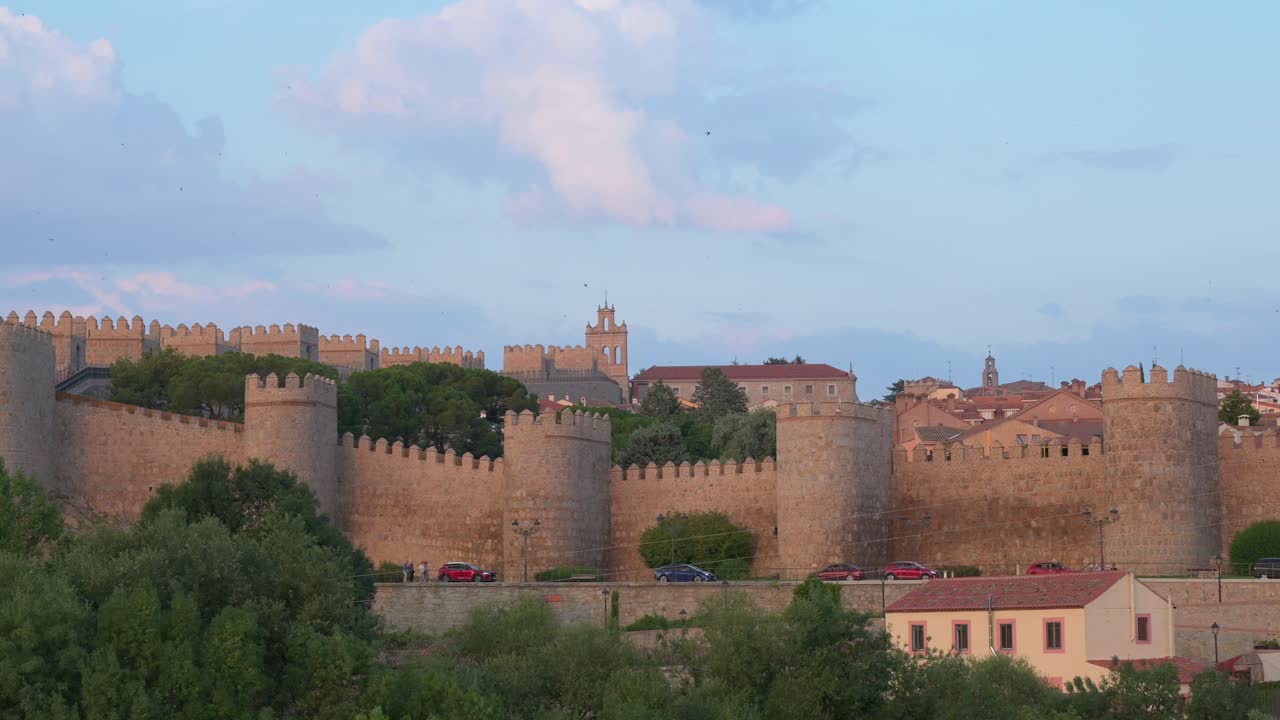 Panning detail shot of Avila during the golden hours of sunset, showcasing the old town and its medieval walls, a UNESCO World Heritage Site.