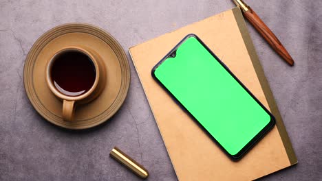 top view of smart phone and notepad on table