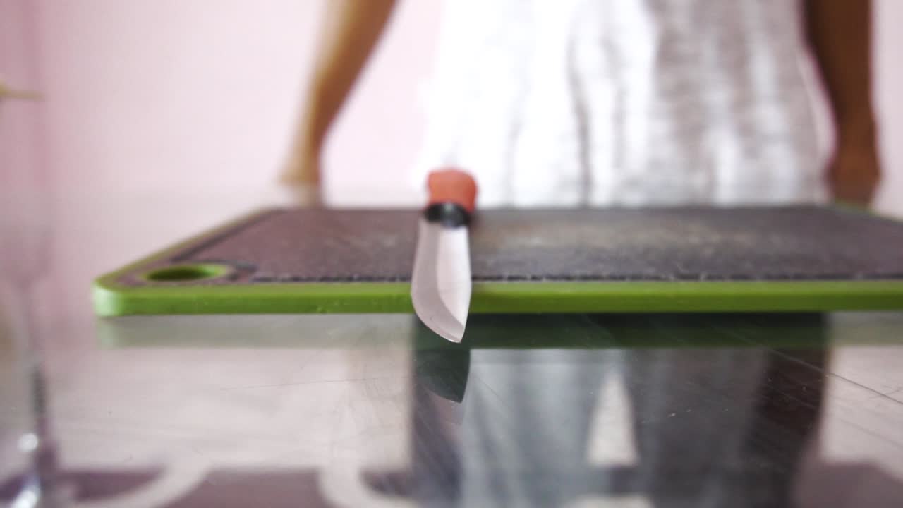 Young man with chopping board and chopping knife making salad