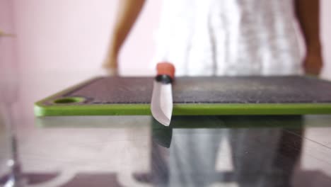 young man with chopping board and chopping knife making salad
