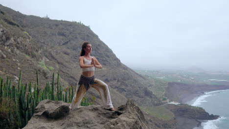 amidst the tranquil beauty of the blue ocean at sunset, a young woman practices yoga on a rocky seashore, illustrating a healthy lifestyle, harmony, and the seamless relationship between humans and nature