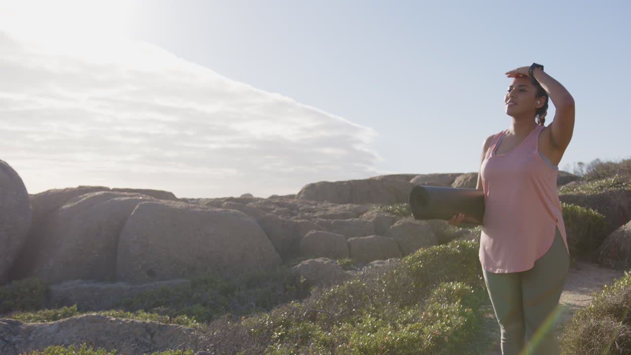Carrying yoga mat, mature asian woman stretching and enjoying outdoor exercise, copy space