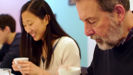 a warm and engaging moment shared between a young woman and an older gentleman at a cozy café, enjoying beverages and delightful conversation