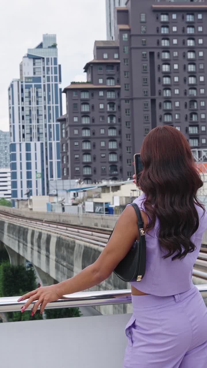 Woman taking photos of the city with a monorail train
