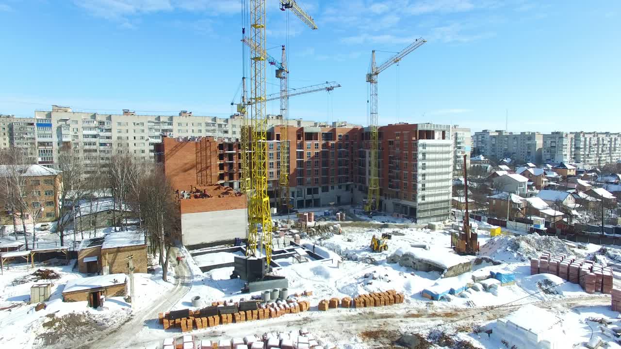 New house construction. Large apartment buildings construction in new district among houses