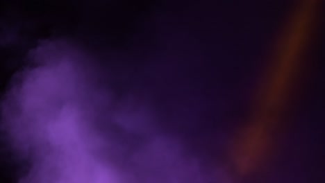 columna de humo con colores enfocados en el escenario en un espectáculo