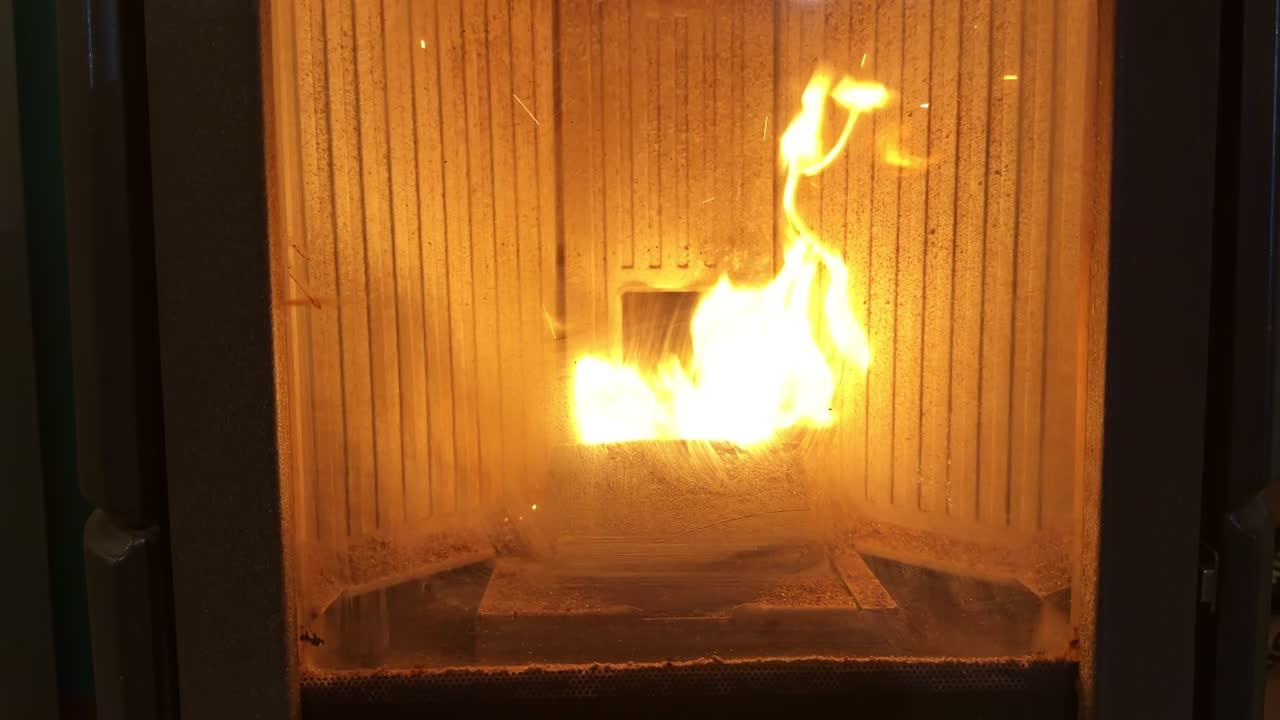 Varm, brændende ild i en traditionel håndværkerpejs i hjemlige omgivelser