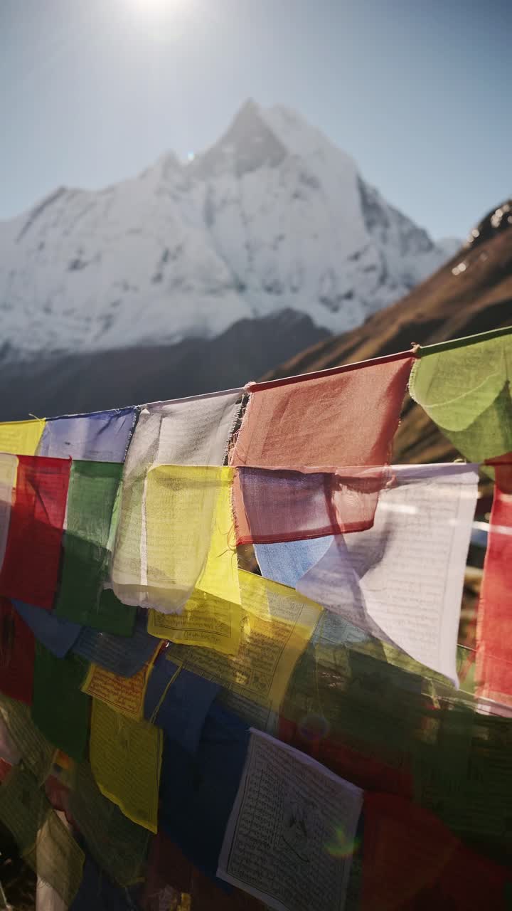 Colourful Buddhist Prayer Flags Close Up in Nepal Mountains, Vertical Video for Social Media Instagram Reels and Tiktok of Colourful Tibetan Prayer Flags with Sunshine and Sun in the Himalayas