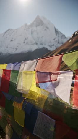 colourful buddhist prayer flags close up in nepal mountains, vertical video for social media instagram reels and tiktok of colourful tibetan prayer flags with sunshine and sun in the himalayas