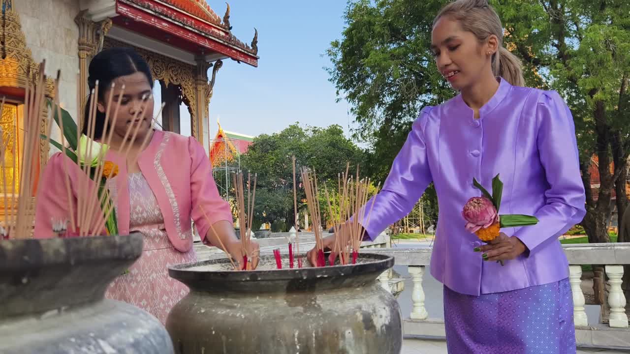 태국 사원 에서 기도 하고 향을 바치는 여자 들