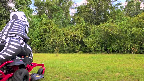 skeleton inflatable dinosaur costume mowing grass on zero turn mower