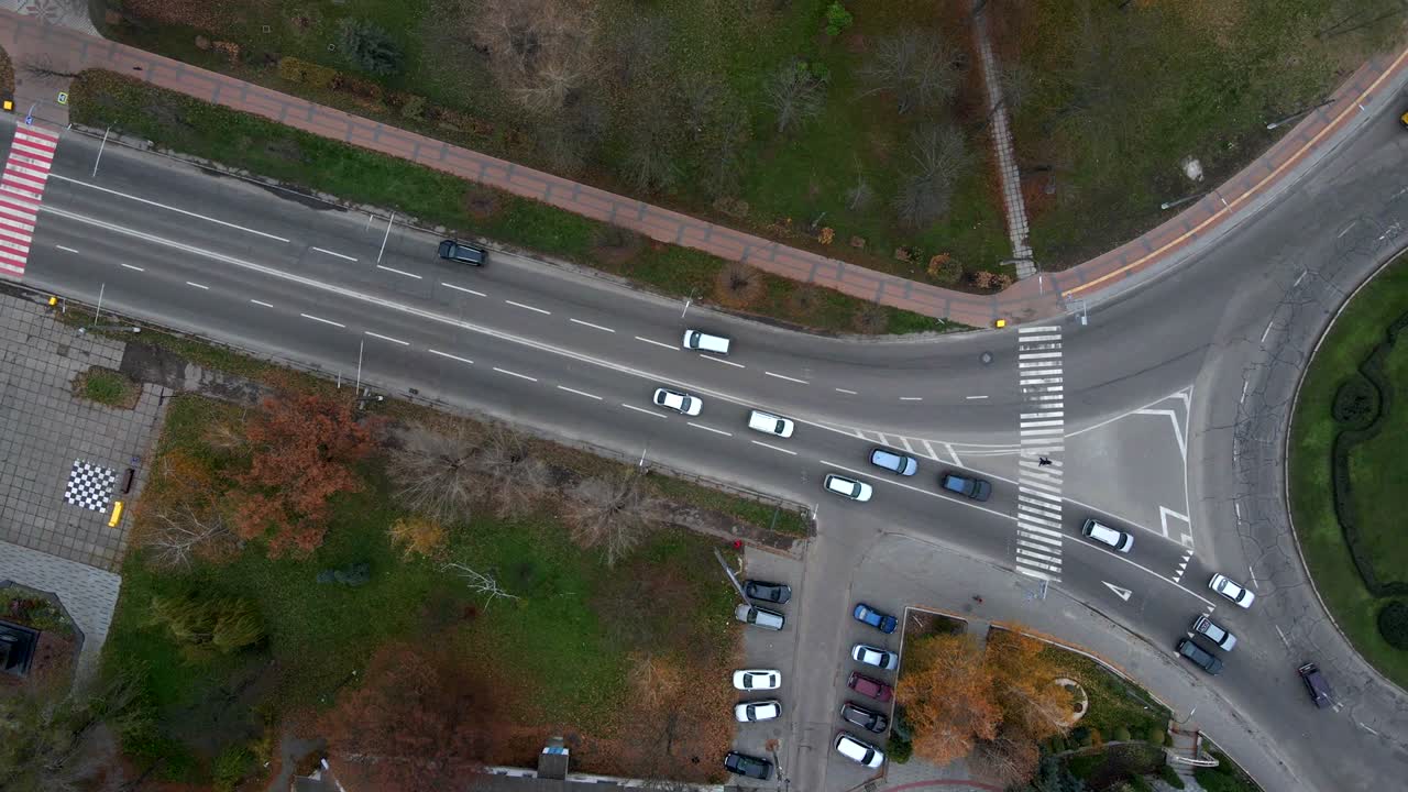 vista aérea de 4k de la carretera de rotonda con coches circulares en una pequeña ciudad europea en un día nublado de otoño