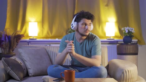depressed man listening to music at home at night.
