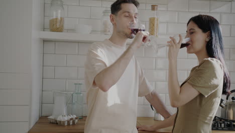 couple enjoying wine in kitchen