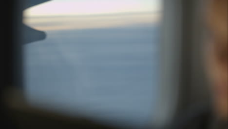 woman using pad during flight and looking out the window