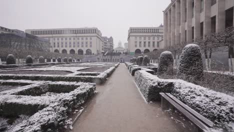 Avanzando-Lentamente-En-Los-Hermosos-Jardines-De-Mont-Des-Arts-En-Bruselas,-Bélgica-Durante-Las-Nevadas---Disparo-De-Seguimiento-Pov