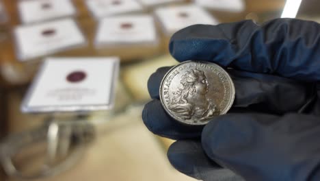 collector examining portuguese copper coin from the modern age