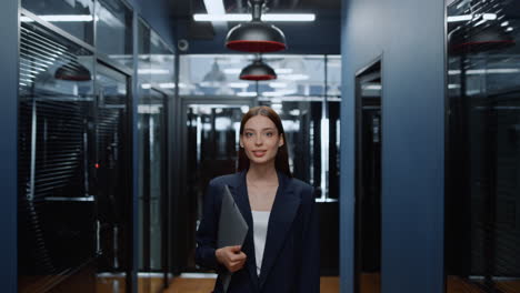 Positive-woman-holding-folder-in-business-center.-Businesswoman-staring-at-lens