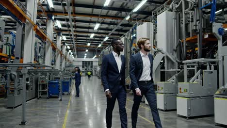 businessmen inspecting factory machinery