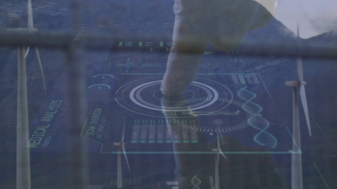 Male operator's hand tapping central reticle over wind turbines, initiating medical analysis HUD